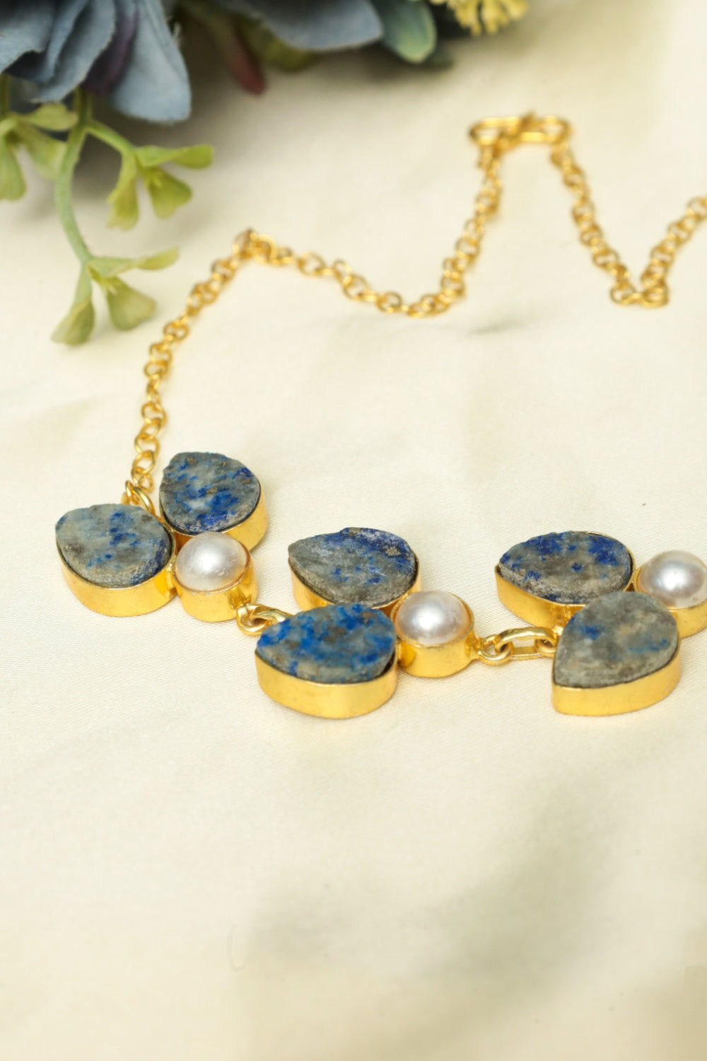 Necklace with blue stones and pearls on a light background